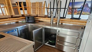 Eine kleine Küche mit Geschirrspüler, Backofen und Kaffeemaschine.