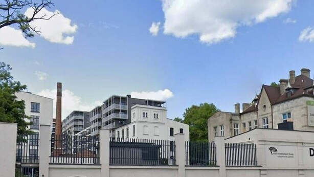 A gated residential area with modern buildings, a fence, and a clear sky. - A comfortable apartment in the center of Łódź (Lodz)
