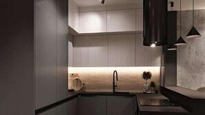 A modern kitchen with a central island, a sink, and pendant lighting. - A comfortable apartment in the center of Łódź (Lodz)