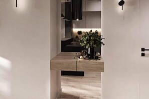 A modern interior with a wooden counter, a potted plant, and a minimalist design. - A comfortable apartment in the center of Łódź (Lodz)