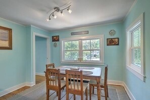 A dining area with a table and chairs, a window with a view, and a ceiling light fixture. - `Pirates Perch` - Walkable to everything Folly! (Folly Beach)
