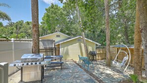 A backyard with a barbecue grill, a table, chairs, and a swing set. - `Pirates Perch` - Walkable to everything Folly! (Folly Beach)