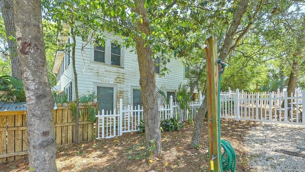 A residential property with a white picket fence, a wooden deck, and a house with a green door. - `Pirates Perch` - Walkable to everything Folly! (Folly Beach)