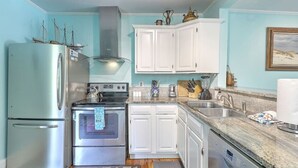 A compact kitchen with white cabinets, stainless steel appliances, and a granite countertop. - `Pirates Perch` - Walkable to everything Folly! (Folly Beach)