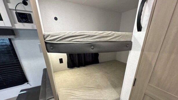 A compact room with a bunk bed, a small desk with a chair, and a window with blinds. - New RV camper in great nature,spring valley (Hamden)