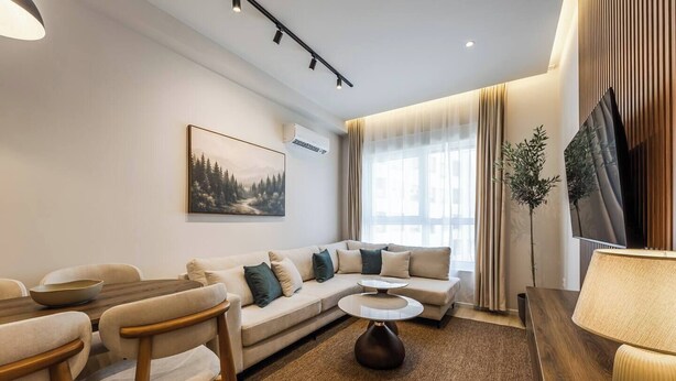 Een moderne woonkamer met een bank, salontafel en stoelen.