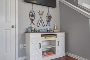 A white cabinet with a flat-screen TV mounted above it. - Monkey Island Nautical Escape (Afton)