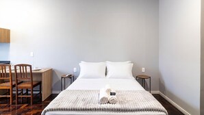 A hotel room with a bed, two bedside tables, a desk, and a chair. - Studio in Velha w/ City View Ola0002 (Blumenau)