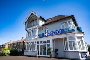 A two-story building with a sign for Heathrow Slough Hotel & Suites.