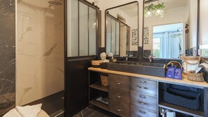 A bathroom with a double vanity, a shower, and a large mirror. - Apartment in the Heart of Deauville With a Garden (Deauville)
