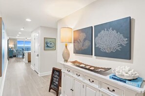 Un vestíbulo de hotel con vista al océano, una recepción y obras de arte en la pared.