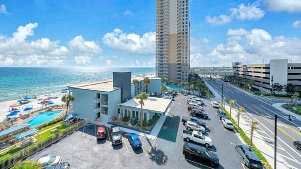 Ein Hotel mit Schwimmbad, Parkplatz und Meerblick.