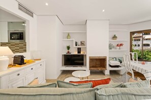Ein modernes Wohnzimmer mit Sofa, Couchtisch, Fernseher und Kamin.