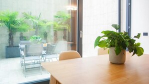 Una sala de conferencias con una mesa de madera, sillas y una planta en maceta.