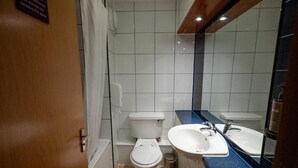 Une salle de bain avec des toilettes, un lavabo et un miroir.