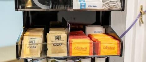 Un expositor escalonado con diversos productos envasados, entre ellos, cajas de azúcar, condimentos y lácteos.