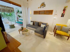 A modern living room with a sofa, armchairs, a coffee table, and a dining area. - Serene Eco Villa 3BR and private pool (Las Terrenas)