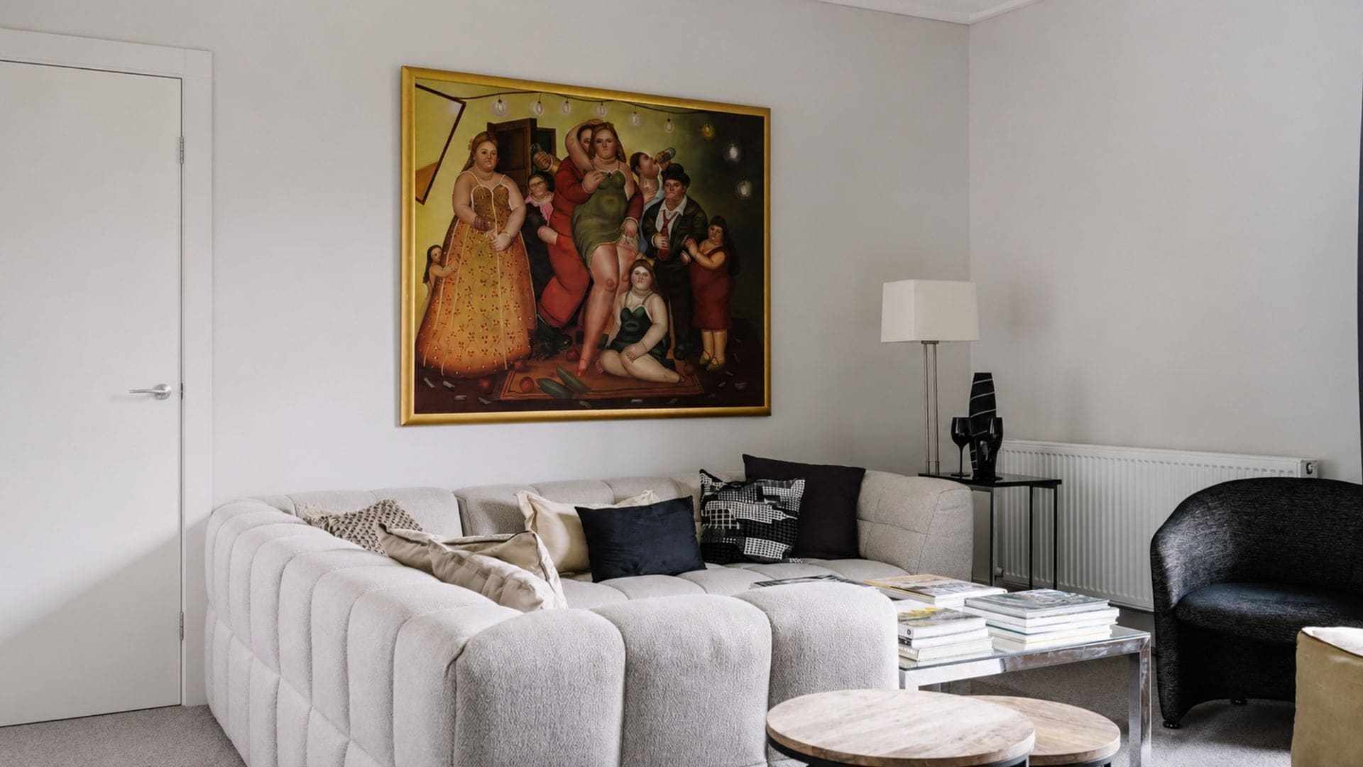 Ein stilvolles Wohnzimmer mit einem großen Gemälde, einem Sofa, einem Couchtisch und einem Sessel.