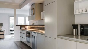 Una cocina moderna con electrodomésticos de acero inoxidable, horno integrado y un reloj en la pared.