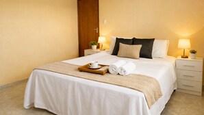 Ein Hotelzimmer mit Bett, Nachttischen, Deckenventilator und einer Tür.