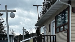 A snow-covered pathway leading to a building with a porch and a staircase. - Cozy 1BR hotel room, Hamilton - #342 Rode-A-Syde (Hamilton)