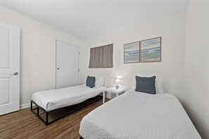 A hotel room with two single beds, a small bedside table with a lamp, and a window with a view of the sea. - 🌊 GS Plantation East 2109 | Gulf View Condo | Resort Pools + Kiva Dunes Golf (Gulf Shores)