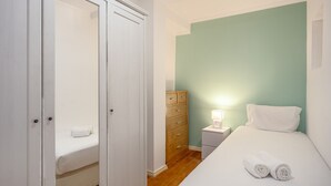 Un dormitorio con cama, mesita de noche, cómoda y armario.