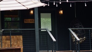 Un edificio rústico con terraza de madera, asientos al aire libre y un letrero que dice 'Hare's Hollow'.
