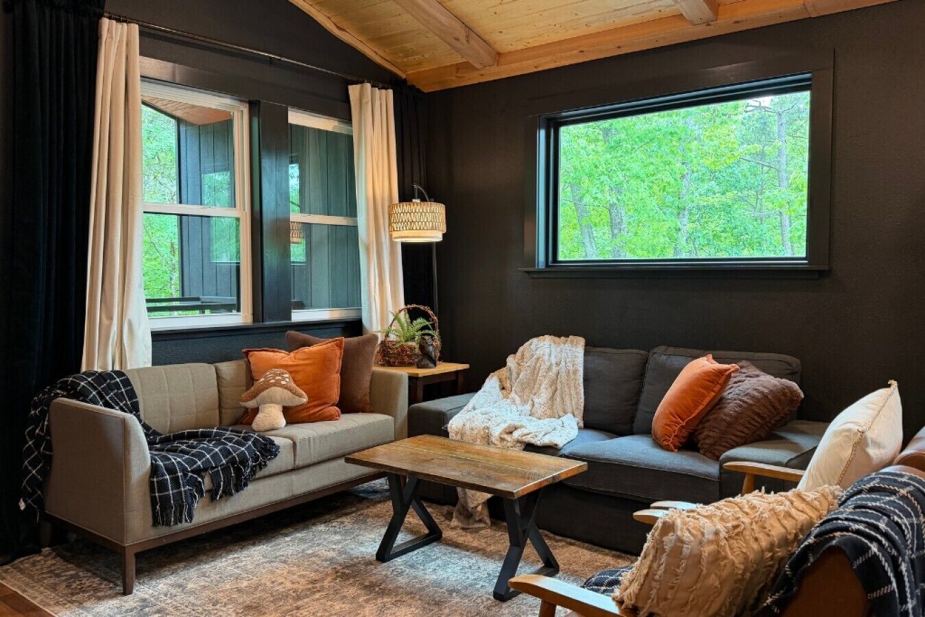 A cozy living room with two sofas, a coffee table, and a window with a view of greenery.
