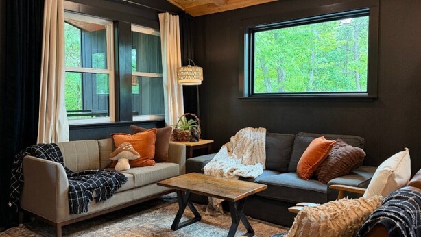 Una sala de estar acogedora con dos sofás, una mesa de centro y una ventana con vistas a zonas verdes.