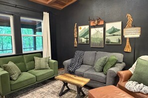 A room with two sofas, a coffee table, and wall art. - Cedar Creek Crossing (all 4 units) (Mena)
