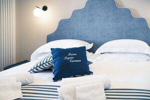 A hotel room with a bed, pillows, and a wall-mounted light fixture. - Maison Regina Giovanna - A Window into Paradise (Sorrento)