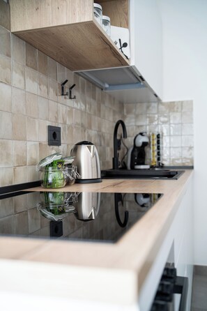 A modern kitchen with a wooden countertop, stainless steel appliances, and a tiled backsplash. - Maison Regina Giovanna - A Window into Paradise (Sorrento)