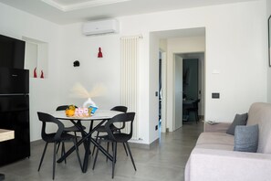 A modern living space with a dining area, a kitchenette, and a seating area. - Maison Regina Giovanna - A Window into Paradise (Sorrento)