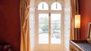 Hotellihuoneen sisäänkäynti, jossa on kaksi ovea, lamppu ja näkymä ulos.