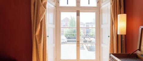A hotel room entrance with a double door, a lamp, and a view of the outside.