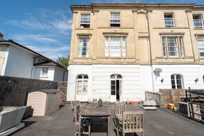 A building with a white facade, multiple windows, and a gated entrance. - 1BDR 1BA Flat on Vibrant Gloucester Road (Bristol City)