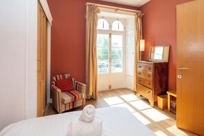 A bedroom with a bed, a chair, a dresser, and a wardrobe. - 1BDR 1BA Flat on Vibrant Gloucester Road (Bristol City)