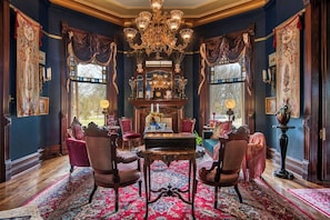 Ein Zimmer mit einem großen Chandelier, aufwendigen Möbeln und einem gemusterten Teppich.