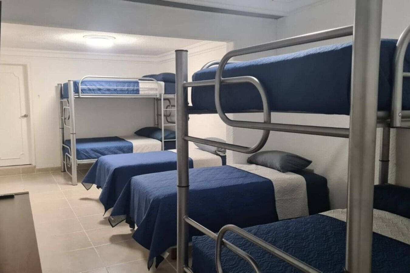 Un dormitorio con literas, un escritorio y una silla.