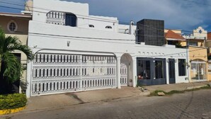 A white building with a gated entrance and a covered area with windows.