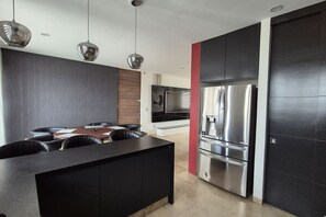 A modern kitchen with a central island, stainless steel appliances, and pendant lighting. - Depa moderno piso7- Recamaras -Elevador+2 cajones (Zapopan)