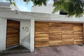 Un bâtiment doté d’une porte de garage et d’un panneau indiquant le numéro de l’immeuble.