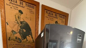 A compact refrigerator in a corner with a tiled floor and two posters on the wall. - Casa Andares 3 REC Y 3 BANOS (Zapopan)