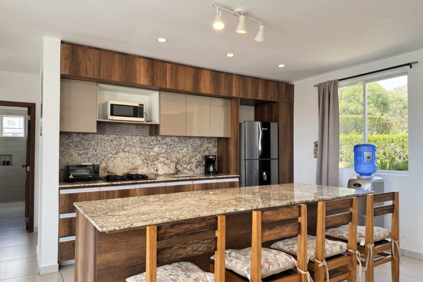 Cafetera o tetera, frigorífico, microondas y mesa de comedor