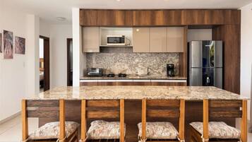 Coffee/tea maker, fridge, microwave, dining table