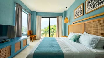 Un dormitorio con una cama grande, un televisor sobre un mueble azul y obras de arte en la pared.