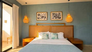 A bedroom with a large bed, two nightstands, a wooden headboard, and two wall-mounted lamps.
