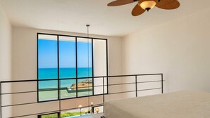 A bedroom with a large window offering a view of the ocean. - Jama Campay Villas by Otium (Camarones)