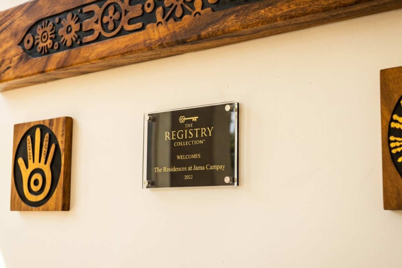 A plaque on a wall with the text 'The Registry Collection Welcomes The Residences at James Campay 2022'.